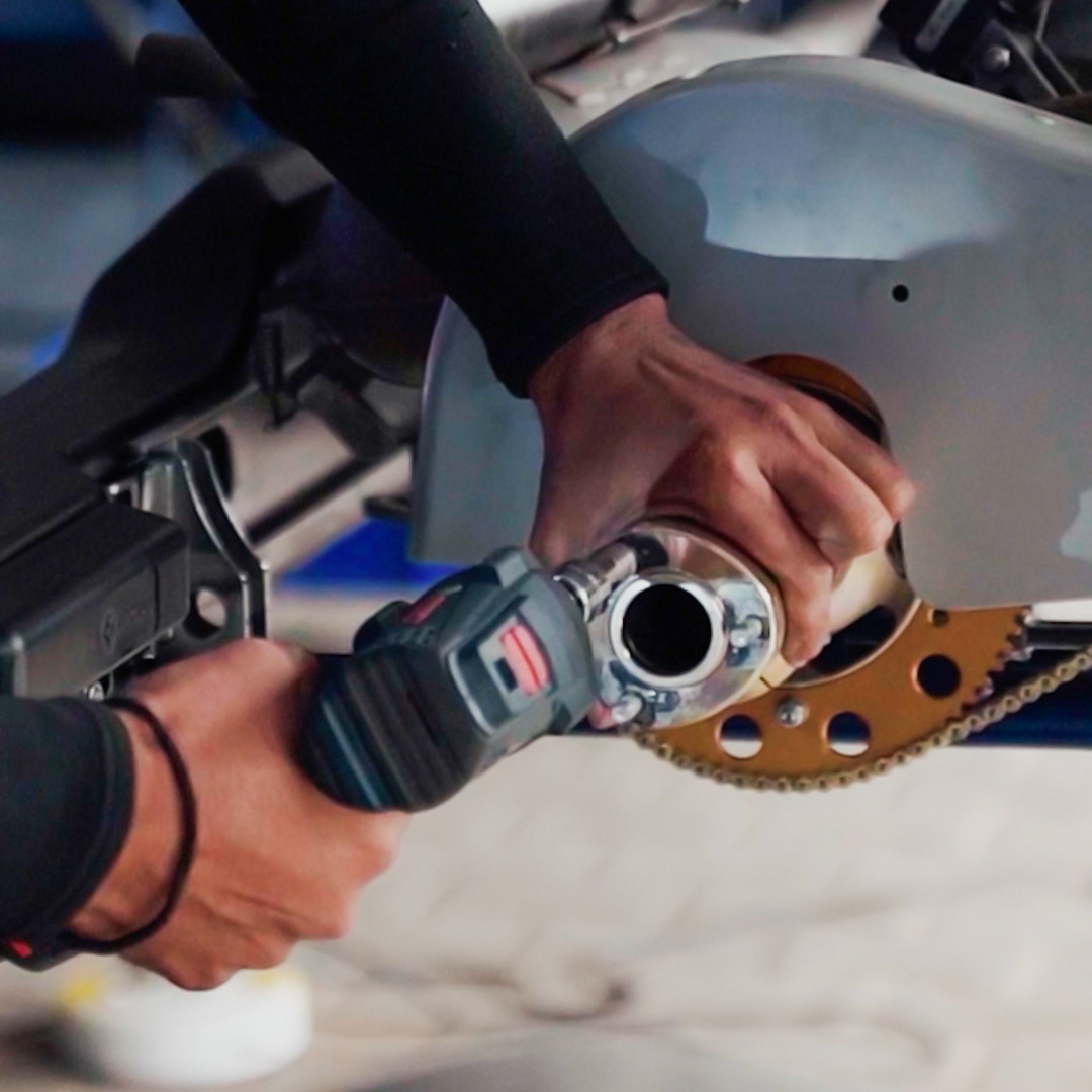 A close-up of someone working on a go-kart engine.